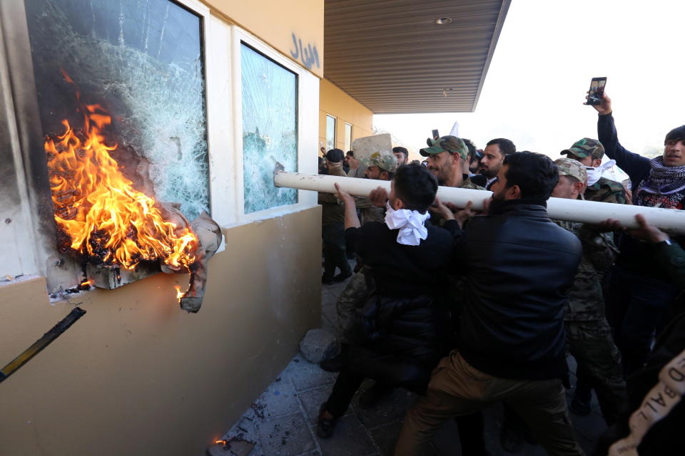 Members of Iraqi Shiite 'Popular Mobilisation Forces' armed group and their supporters attack the entrance of the US Embassy in Baghdad, Iraq.