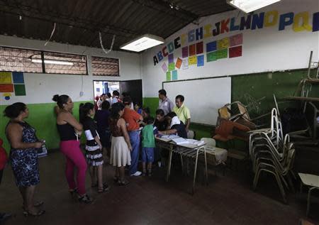 Voters wait in line to cast their votes in the presidential elections at a polling station outside in San Salvador February 2, 2014. REUTERS/Henry Romero