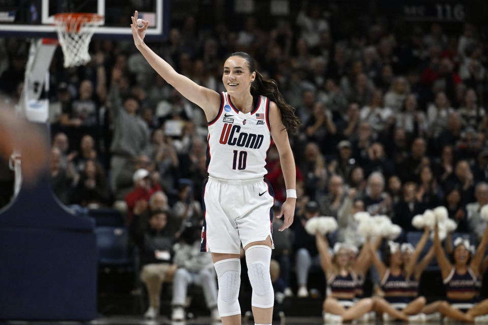 UConn guard Nika Muhl (10) smiles and gestures after assisting on a 3-point basket to teammate Ashlyn Shade to become UConn's all time assist leader in the first half of a second-round college basketball game against Syracuse in the NCAA Tournament, Monday, March 25, 2024, in Storrs, Conn. (AP Photo/Jessica Hill)