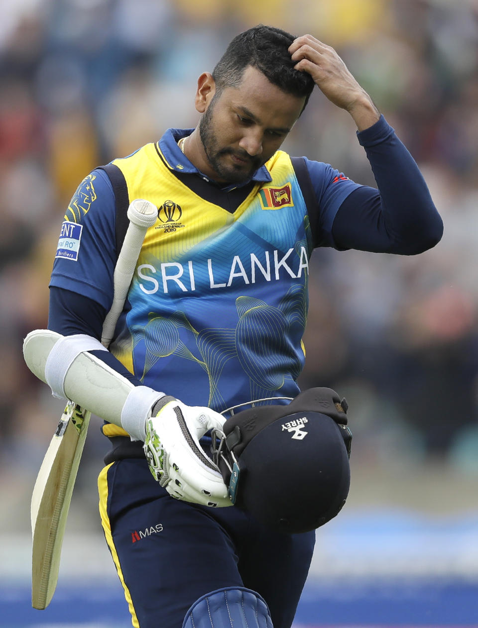 Sri Lanka's captain Dimuth Karunaratne leaves the pitch after he is caught by Australia's Glenn Maxwell for 97 during the World Cup cricket match between Sri Lanka and Australia at The Oval in London, Saturday, June 15, 2019. (AP Photo/Kirsty Wigglesworth)