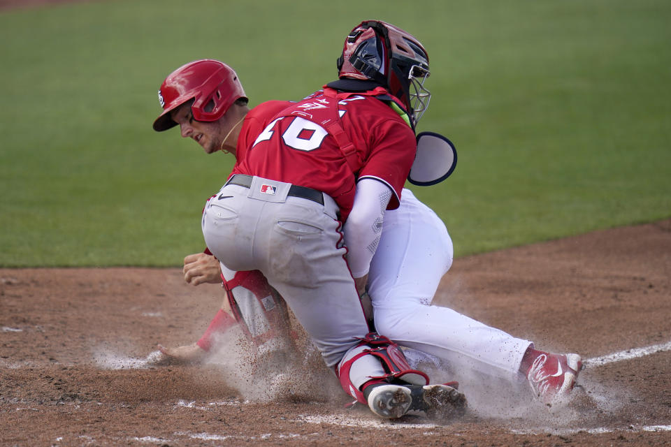 St. Louis Cardinals' Andrew Knizner, rear, is tagged out at home by Washington Nationals catcher Jakson Reetz during the fourth inning of a spring training baseball game Sunday, Feb. 28, 2021, in Jupiter, Fla. (AP Photo/Jeff Roberson)