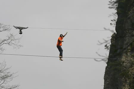 American climber Dean Potter walks barefooted on a rope which is connected between two mountain peaks in Enshi, Hubei province, China, in this file photo taken April 22, 2012. REUTERS/China Daily/Files