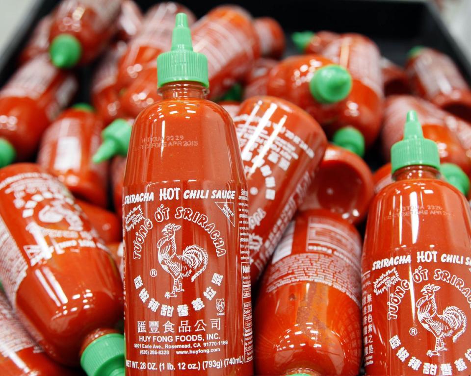 Sriracha chili sauce bottles are produced at the Huy Fong Foods factory in Irwindale, Calif., on Tuesday, Oct 29, 2013. The maker of Sriracha hot sauce is under fire for allegedly fouling the air around its Southern California production site. The city of Irwindale filed a lawsuit in Los Angeles Superior Court Monday asking a judge to stop production at the Huy Fong Foods factory, claiming the chili odor emanating from the facility is a public nuisance. (AP Photo/Nick Ut)