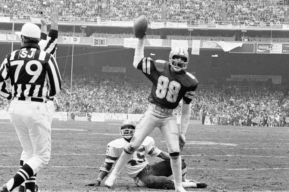 FILE - In this Jan. 22, 1983, file photo, Drew Pearson (88) of the Dallas Cowboys holds the ball after scoring their first touchdown against the Washington Redskins during the NFC Championship game at RFK Stadium in Washington. Redskins' Jeris White sits on ground. Former Dallas Cowboys wide receiver Drew Pearson was selected Tuesday, Aug. 18, 2020, as the Senior Finalist for the Pro Football Hall of Fame’s Class of 2021. (AP Photo/File)