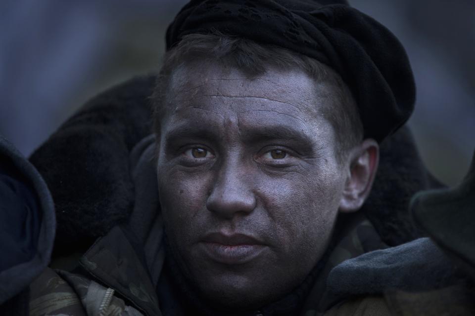 Soot-covered anti-government protester poses for a portrait at a barricade facing riot police in Kiev