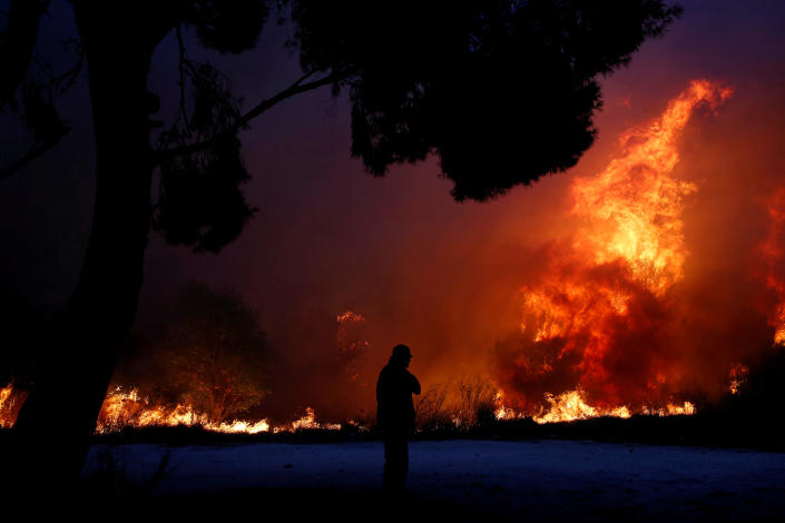<p>A man looks at the flames as a wildfire burns in the town of Rafina, near Athens, Greece, July 23, 2018. REUTERS/Costas Baltas TPX IMAGES OF THE DAY </p>