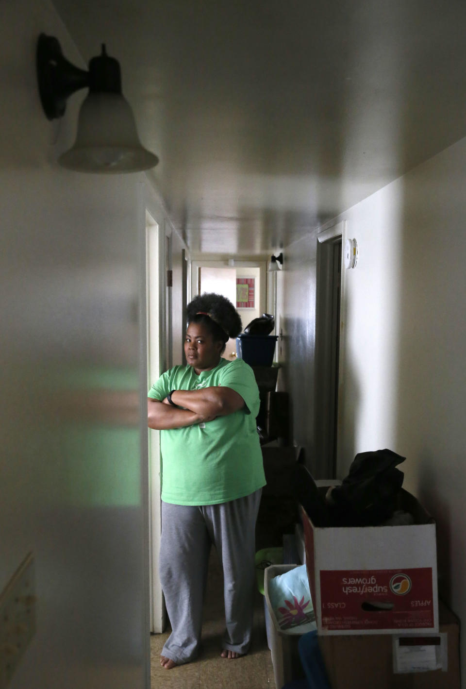 In this Thursday, March 30, 2017, photo, Tara Adams poses for a portrait in her home as boxes sit stacked in a hallway waiting for an impending move from her East Chicago, Ind., home. Adams is one of dozens of families in this former industrial town who have yet to be evacuated from a housing project ordered emptied by the mayor because of severe lead contamination. (AP Photo/Charles Rex Arbogast)