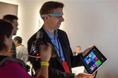 An attendee wearing Google glass uses the new Microsoft Surface Pro 3, during the event in New York May 20, 2014. REUTERS/Brendan McDermid