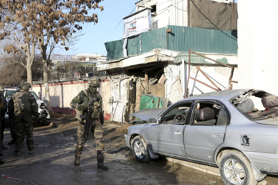 NATO International security assistance forces personnel investigate at the site of the Friday's suicide attack and shooting, in Kabul, Afghanistan, Saturday, Jan. 18, 2014. A Taliban suicide bomber and two gunmen on Friday attacked a Lebanese restaurant that is popular with foreigners and affluent Afghans in Kabul, a brazen attack that left 16 dead, including foreigners dining inside and two other gunmen, officials said. (AP Photo/Rahmat Gul)