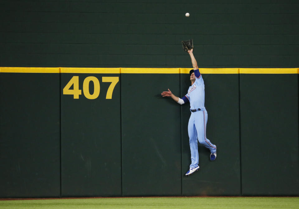 Texas Rangers centerfielder Eli White attempts to catch a home run by Oakland Athletics' Jed Lowrie during the second inning of a baseball game in Arlington, Texas, Sunday, July 11, 2021. (AP Photo/Ray Carlin)
