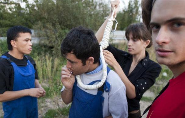 Political activists Pyotr Verzilov (R) and his wife Nadezhda Tolokonnikova prepare a migrant worker for a mock execution at a Moscow megastore, September 7, 2008. Tolokonnikova later became a member of Pussy Riot.