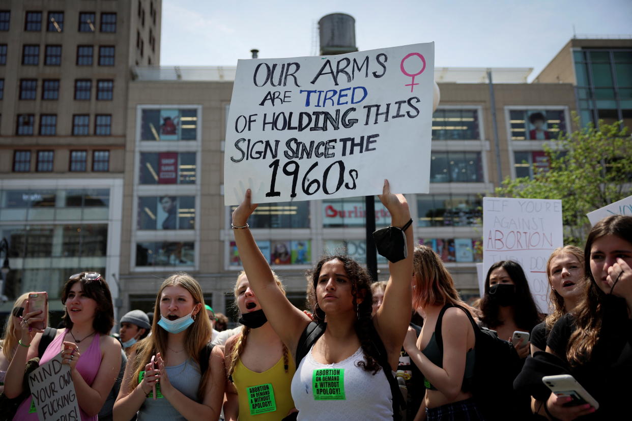 One protester holds a sign saying, Our arms are tired of holding this sign since the 1960s.