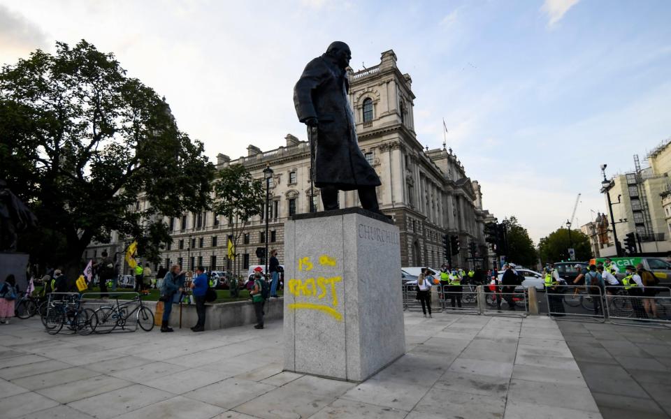The statue of Winston Churchill in Parliament Square is seen with graffiti reading 'is a racist' on the plinth - AP Photo/Alberto Pezzali
