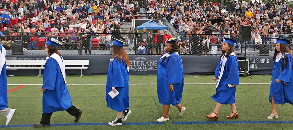 Friends and family watch as members of Quincy High School's Class of 2023 file into Veterans Stadium on Monday, June 5, 2023.