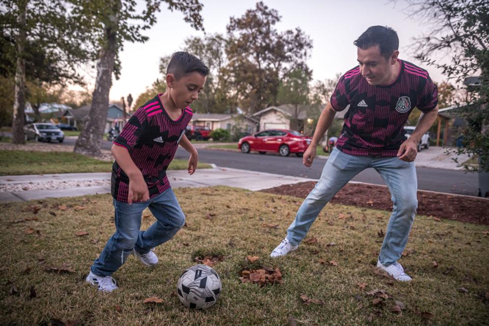Sergio Tristán and his son Alejandro practice soccer in Mexico jerseys in the front yard of their North Austin home last week. Sergio is the founder of Pancho Villa’s Army, a supporters’ group for the Mexican national team.