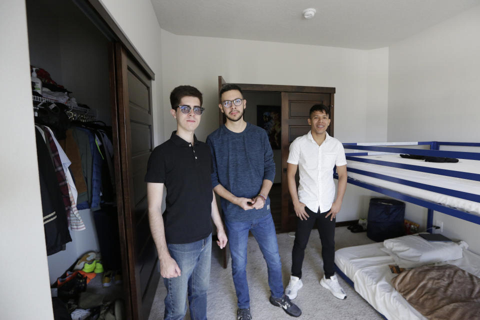 Cesar Baez, Henry Nadales, center, and Jenderson Rondon, who are beneficiaries of the Venezuelan humanitarian parole program poses for a photograph in their room at the house of Dr. Kyle Varner, who is their program sponsor, Friday, Jan. 6, 2023, in Spokane, Wash. (AP Photo/Young Kwak)