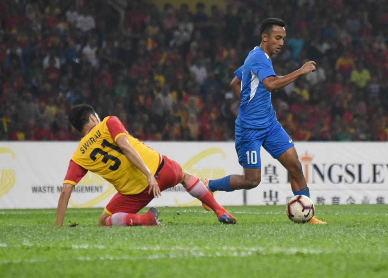 Singapore's Faris Ramli (right) dribbling past Selangor's Nicholas Ryan Swirad in the Sultan of Selangor Cup match at Shah Alam Stadium. (PHOTO: Zainal Yahya/Yahoo News Singapore)