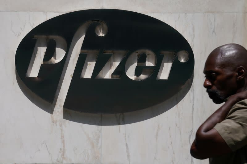 FILE PHOTO: A man walks past a sign outside Pfizer Headquarters in the Manhattan borough of New York City