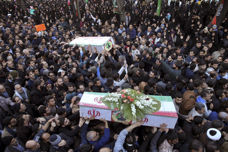 Mourners carry flag-draped caskets during a mass funeral for those killed in a suicide car bombing that targeted members of Iran's powerful Revolutionary Guard in earlier in the week, killing at least 27 people, in Isfahan, Iran, Saturday, Feb. 16, 2019. The head of the Guard has threatened to retaliate against neighboring Saudi Arabia and United Arab Emirates over the bombing. (AP Photo/Ebrahim Noroozi)