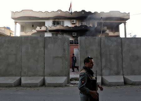 Afghan policemen stand guard outside the Iraqi embassy after an attack in Kabul, Afghanistan July 31, 2017.REUTERS/Mohammad Ismail