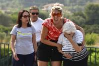 Local residents react during a wildfire near Olympia town, western Greece, Thursday, Aug. 5, 2021. Wildfires rekindled outside Athens and forced more evacuations around southern Greece Thursday as weather conditions worsened and firefighters in a round-the-clock battle stopped the flames just outside the birthplace of the ancient Olympics. (Giannis Spyrounis/ilialive.gr via AP)