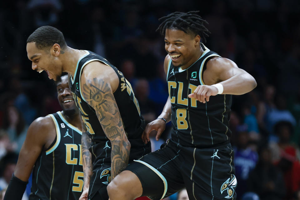 Charlotte Hornets guard Dennis Smith Jr. (8) celebrates with Charlotte Hornets forward P.J. Washington after Smith dunked against the Dallas Mavericks during the second half of an NBA basketball game in Charlotte, N.C., Sunday, March 26, 2023. Charlotte won 110-104. (AP Photo/Nell Redmond)