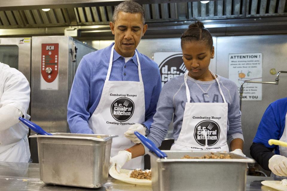President Barack Obama and his daughter Sasha, right, make burritos at DC Central Kitchen as part of a service project in honor of Martin Luther King, Jr. Day, Monday, Jan. 20, 2014, in Washington. Also helping were first lady Michelle Obama and daughter Malia Obama. (AP Photo/Jacquelyn Martin)