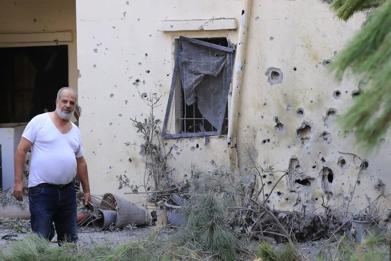 Un hombre libanés se encuentra en su patio, que fue alcanzado por el fuego de artillería israelí en la aldea de Dahaira, en el sur de Líbano, el lunes, 9 de octubre de 2023.