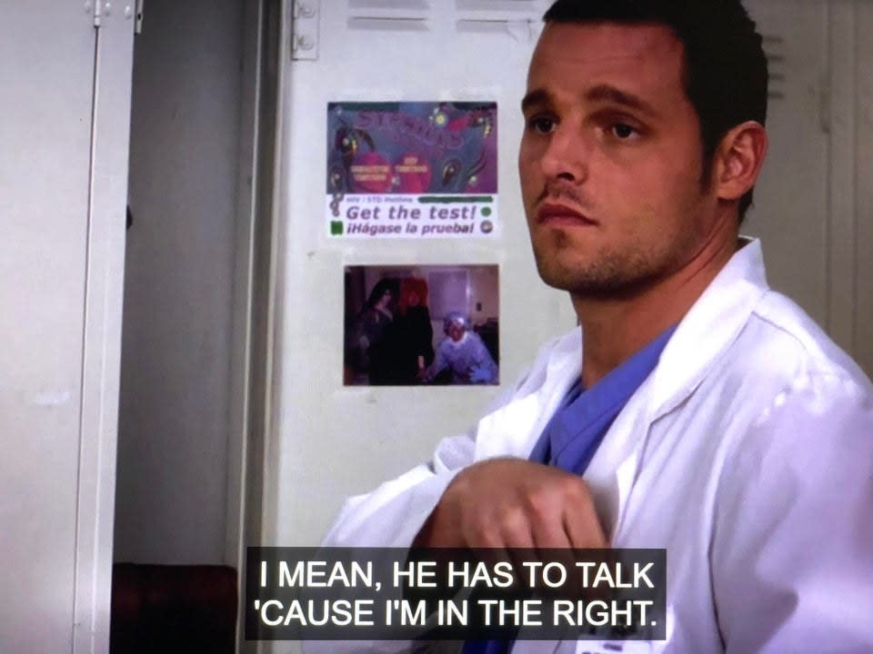 Alex standing in front of an open locker, which is decorated with a photo and a sticker saying 'syphilis, get the test'