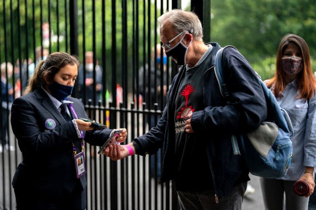 A spectator has a mobile ticket checked at the gate on day one of Wimbledon 