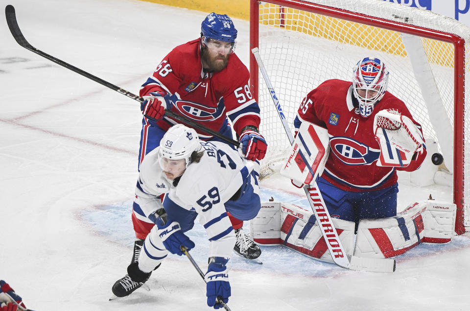 Montreal Canadiens' David Savard (58) defends against Toronto Maple Leafs' Tyler Bertuzzi (59) as he moves in on Canadiens goaltender Sam Montembeault (35) during the first period of an NHL hockey game in Montreal, Saturday, April 6, 2024. (Graham Hughes/The Canadian Press via AP)