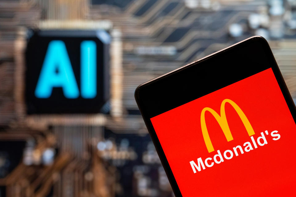 CHINA - 2023/11/03: In this photo illustration, the American fast-food hamburger restaurant chain McDonald's logo seen displayed on a smartphone with an Artificial intelligence (AI) chip and symbol in the background. (Photo Illustration by Budrul Chukrut/SOPA Images/LightRocket via Getty Images)