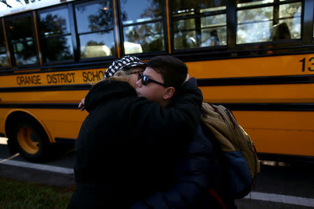 Puerto Rican Felix Rodriguez, 11, hugs his mother Nydia Irizarry, 45, before a school bus picks him up outside a hotel where he lives with his family, in Orlando, Florida, U.S., December 11, 2017. REUTERS/Alvin Baez