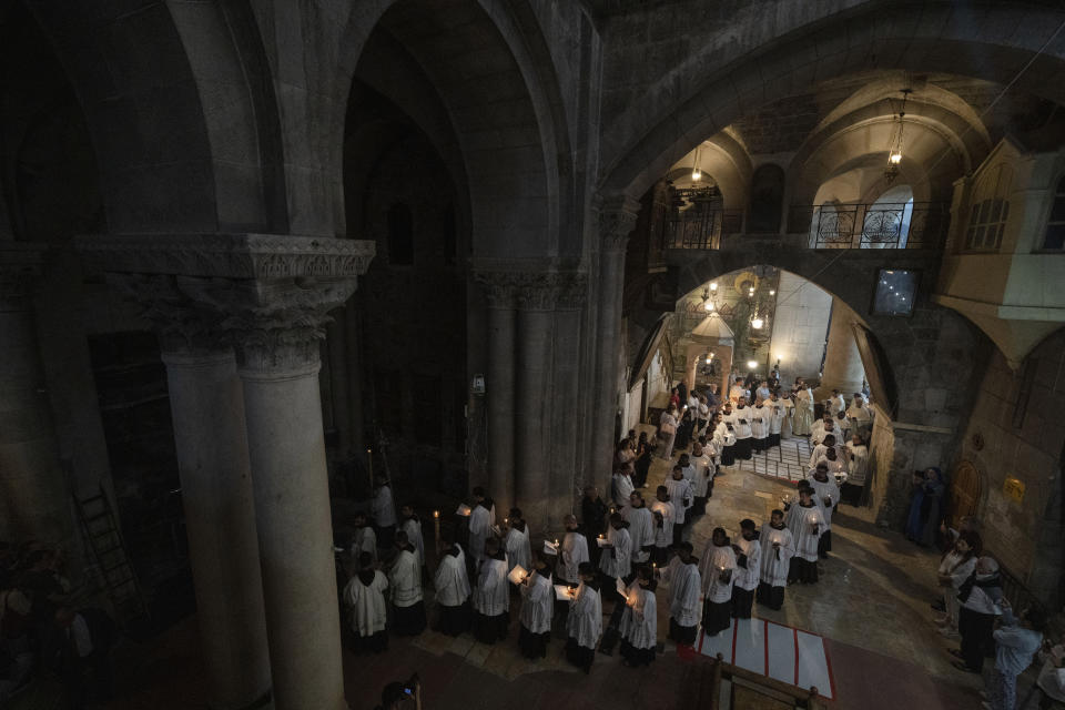 Clergymen walk in a procession around the Stone of Unction, which is traditionally claimed as the stone where Jesus' body was prepared for burial during Easter Sunday Mass at the Church of the Holy Sepulchre, in the Old City of Jerusalem, Sunday, March 31, 2024, where many Christians believe Jesus Christ was crucified, buried and rose from the dead. (AP Photo/Leo Correa)