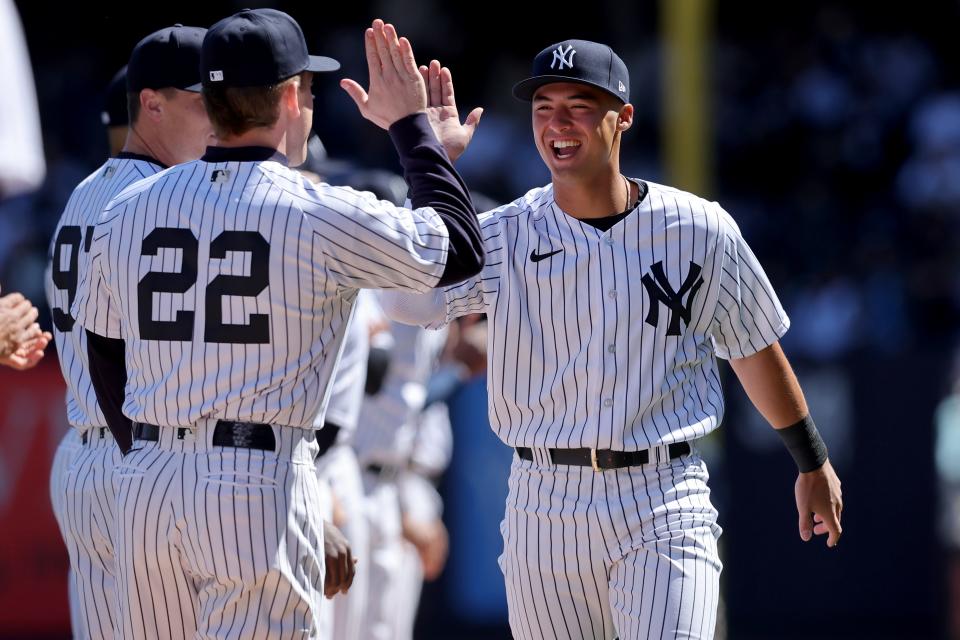 Mar 30, 2023; Bronx, New York, USA; New York Yankees shortstop Anthony Volpe (11) high fives center fielder Harrison Bader (22) as he is introduced before an opening day game against the San Francisco Giants at Yankee Stadium. Mandatory Credit: Brad Penner-USA TODAY Sports