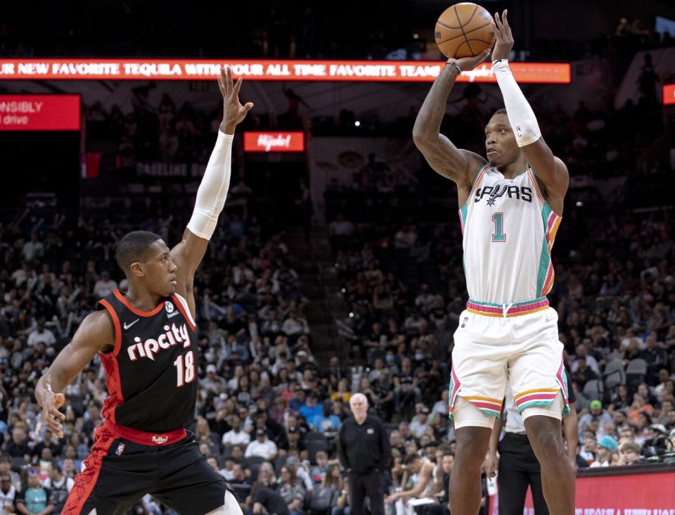 San Antonio Spurs guard Lonnie Walker IV shoots a 3-pointer over Portland Trail Blazers guard Kris Dunn.