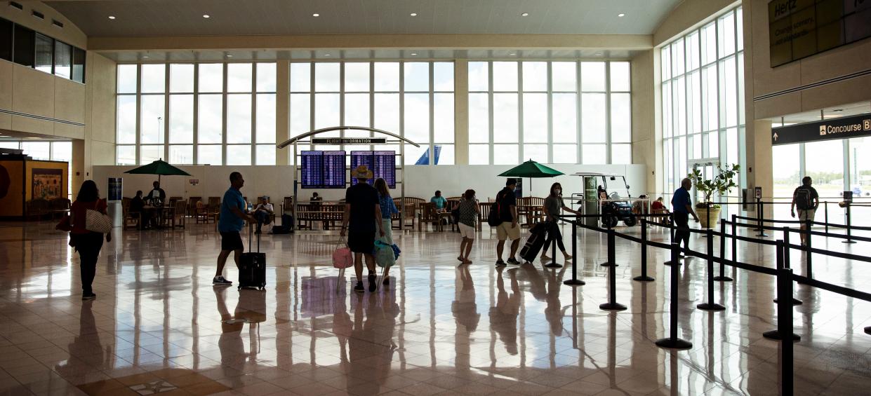 Passengers and others walk past ongoing construction at Southwest Florida International Airport on Tuesday, May 31, 2022.