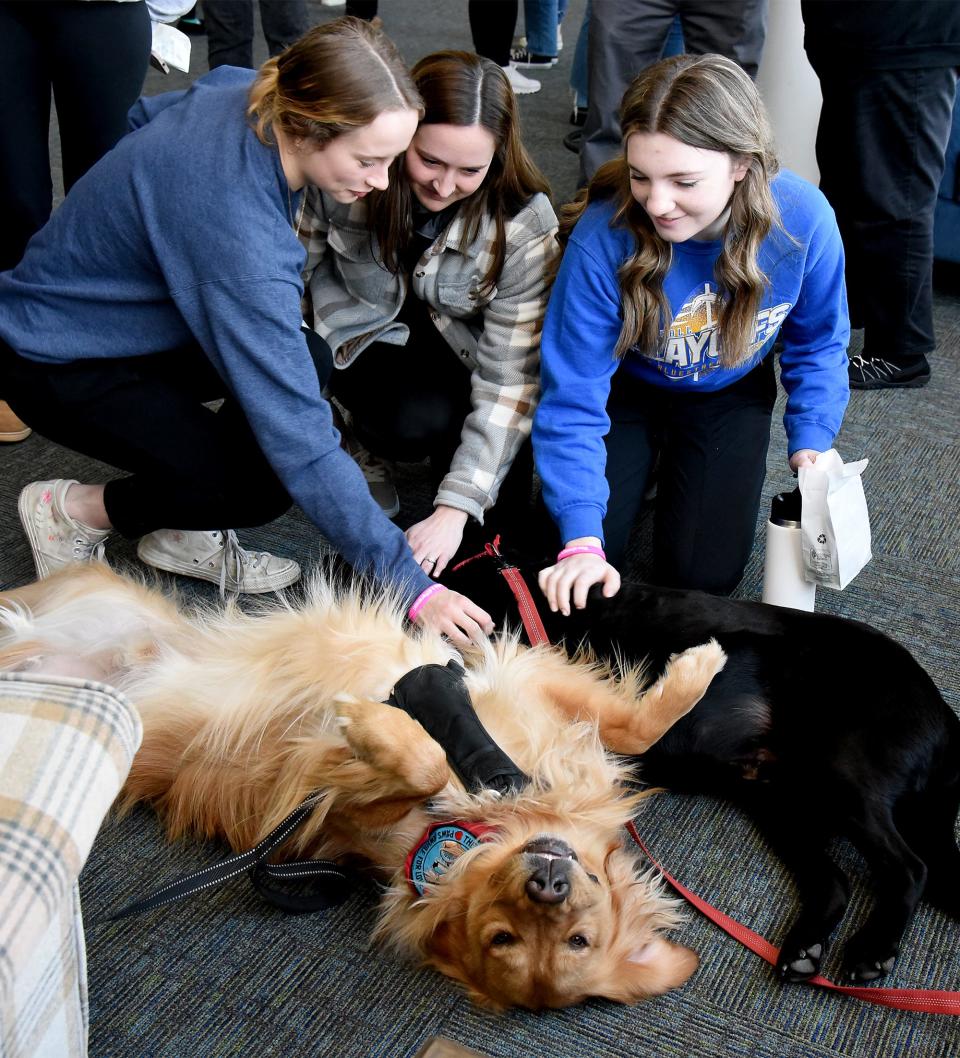 Ida High School senior Reagan Horn (left) and sophomore Autumn Anastrasoff (right) along with their adviser, Katie Shopshire, pet therapy dogs Geordie, a golden retriever, and Brody, a black Labrador. The dogs are from Therapy Dogs International.