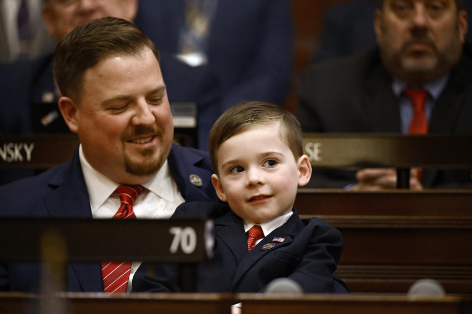 Jonathan Bronko, 4, sits on his father State Rep. Seth Bronko, R-Naugatuck, during opening session at the State Capitol, Wednesday, Feb. 7, 2024, in Hartford, Conn. (AP Photo/Jessica Hill)