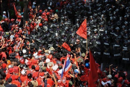 Red-shirted supporters of fugitive former Thai premier Thaksin Shinawatra scuffle with Thai riot police during anti-government protests in Bangkok in April 2010. Thailand's Prime Minister Abhisit Vejjajiva has said he will ask the king to dissolve parliament for the country's first general election since deadly political violence rocked Bangkok last year