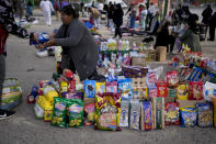 A vendor completes a transaction at a market where people can buy or barter goods, on the outskirts of Buenos Aires, Argentina, Wednesday, Aug. 10, 2022. Argentina has one of the world’s highest inflation rates, currently running at more than 60% annually, according to the National Institute of Statistics and Census of Argentina (INDEC). (AP Photo/Natacha Pisarenko)