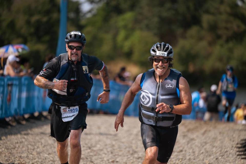 Rene Torres, of Sacramento right, crosses the finish line with Javier Ramirez, of South San Francisco, left, with a time of 2:36:27 at the Great American Triathlon on Saturday, July 20, 2024.
