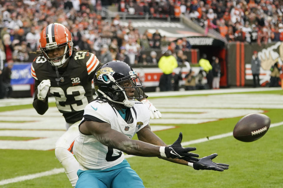 Jacksonville Jaguars wide receiver Calvin Ridley (0), defended by Cleveland Browns cornerback Martin Emerson Jr. (23), catches short of the goal line during the second half of an NFL football game, Sunday, Dec. 10, 2023, in Cleveland. (AP Photo/Sue Ogrocki)