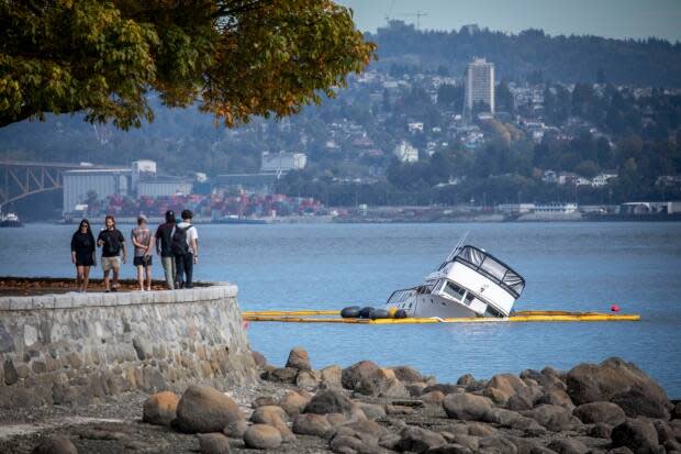 A crew works to prevent a capsized yacht from spilling fuel into the water in Vancouver's Coal Harbour on Monday, Sept. 21, 2021.  (Ben Nelms/CBC - image credit)