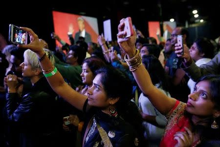 Attendees watch Republican presidential nominee Donald Trump speak at a Bollywood-themed charity concert put on by the Republican Hindu Coalition in Edison, New Jersey, U.S. October 15, 2016. REUTERS/Jonathan Ernst