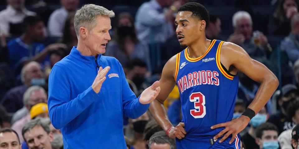 Steve Kerr speaks to Jordan Poole during a game in 2022.