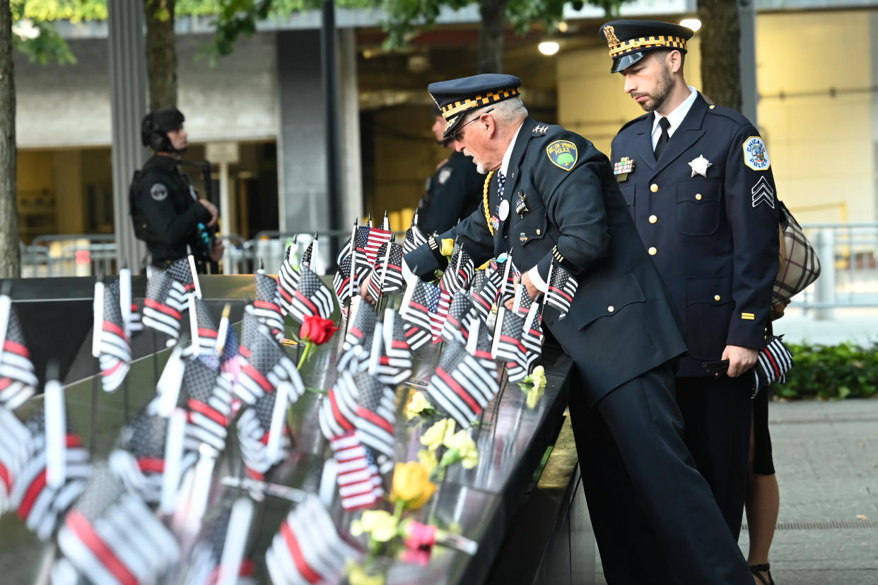 NEW YORK, NEW YORK - SEPTEMBER 11: Retired Willow Springs, IL Chief Sam Pulia and his nephew, Chicago Police Sgt. Daniel Pulia place flags at the South Tower before a ceremony at the National September 11 Memorial & Museum commemorating the 20th anniversary of the September 11th terrorist attacks on the World Trade Center on September 11, 2021 in New York City. The nation is marking the 20th anniversary of the terror attacks of September 11, 2001, when the terrorist group al-Qaeda flew hijacked airplanes into the World Trade Center, Shanksville, PA, and the Pentagon, killing nearly 3,000 people. (Photo by David Handschuh-Pool/Getty Images)