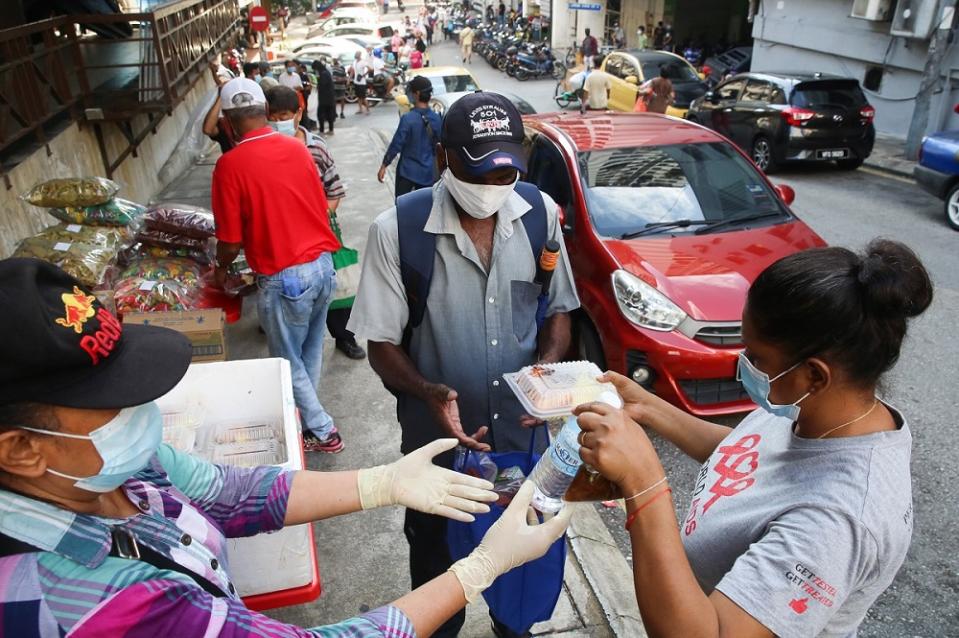 PPKUM president Elisha Kor Krishnan (right) distributing free meals to the needy in Chow Kit. ― Picture by Choo Choy May