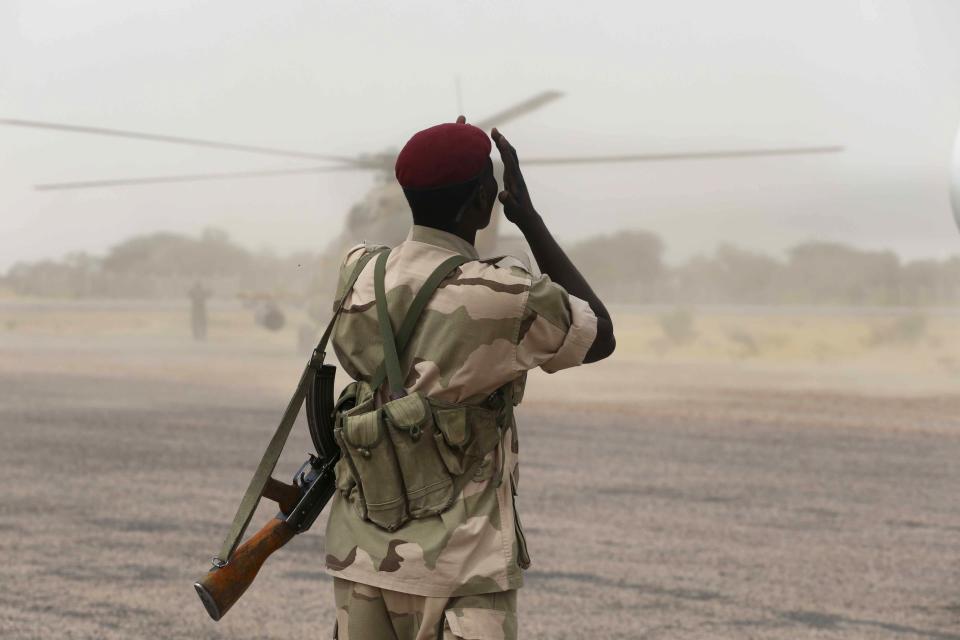 A Chadian soldier shields his face from dust kicked up by a helicopter in the recently retaken town of Damasak, Nigeria, March 18, 2015. Armies from Nigeria, Cameroon, Chad and Niger have launched an offensive to end Boko Haram's six-year campaign, which has killed thousands in northern Nigeria and spilled over into Cameroon and Niger. REUTERS/Emmanuel Braun (NIGERIA - Tags: CIVIL UNREST MILITARY POLITICS)