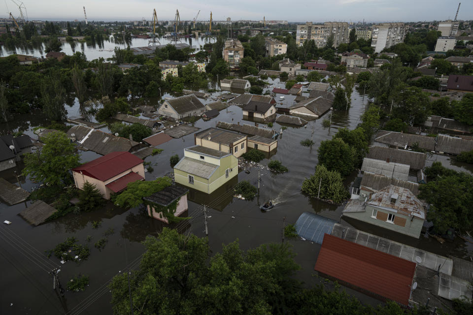 FILE - Ukrainian servicemen ride by boat in a flooded neighborhood in Kherson, Ukraine, Thursday, June 8, 2023. Floodwaters from a collapsed dam kept rising in southern Ukraine on Wednesday, forcing hundreds of people to flee their homes in a major emergency operation that brought a dramatic new dimension to the war with Russia, now in its 16th month. (AP Photo/Evgeniy Maloletka, File)